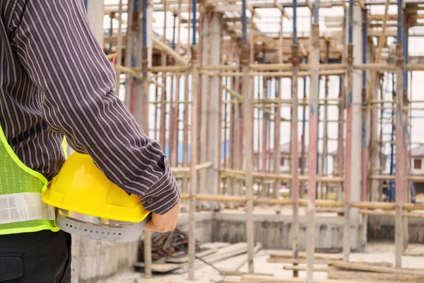 Asyalı işadamı inşaat mühendisi. İnşaat alanında koruyucu miğferi var.