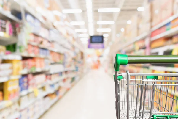 Boş yeşil süpermarket alışveriş arabası soyut bulanık market koridoru odaklanmış arka plan