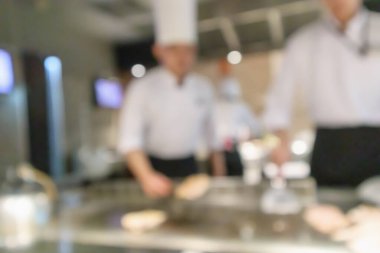 Lokanta mutfağında aşçı bulanık arka planda kalmış.