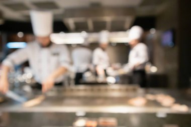 Lokanta mutfağında aşçı bulanık arka planda kalmış.