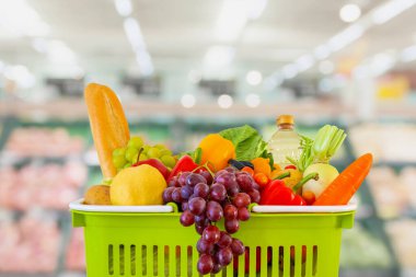 Meyve ve sebzelerle dolu alışveriş sepeti süpermarket marketi ile bulanıklaştırılmış arka plan bokeh ışığı ile bulanıklaştırılmış