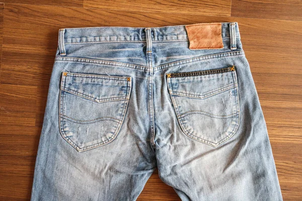 Denim Blå Jeans Med Blank Läder Etikett Trä Bakgrund — Stockfoto