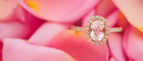 美しいバラの花びらの背景にジュエリーピンクのダイヤモンドリングを閉じる — ストック写真