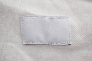 Pamuk gömlek arka planında beyaz boş giyim etiketi