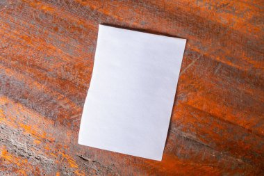 Eski ahşap masa arka planında boş beyaz kağıt