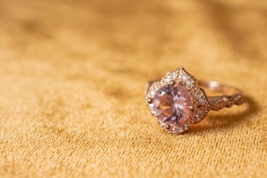 Altın kumaş kaplamalı pembe elmas yüzük. Yakın plan.