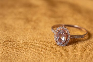 Altın kumaş kaplamalı pembe elmas yüzük. Yakın plan.