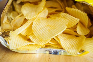 Tahta masada patates cipsi açık.