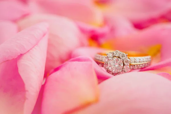Jewelry diamond ring on beautiful pink rose petal background close up