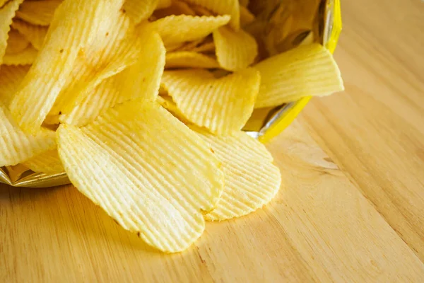 Tahta masada patates cipsi açık.