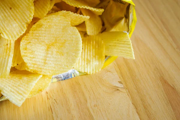 Tahta masada patates cipsi açık.