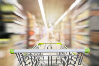Süpermarket koridorundaki alışveriş arabasının içinde ürün rafları iç odaklanmış bulanık arkaplan