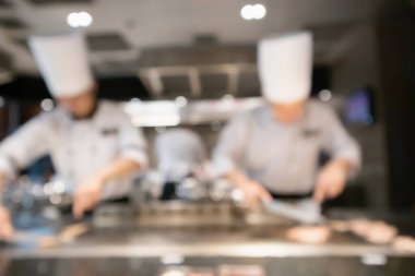 Lokanta mutfağında aşçı bulanık arka planda kalmış.