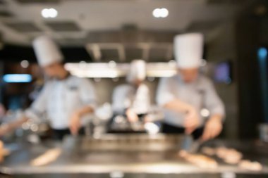 Lokanta mutfağında aşçı bulanık arka planda kalmış.