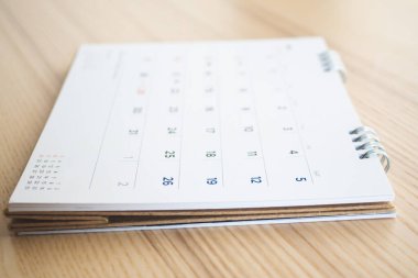 Tahta masa arkaplanındaki takvim sayfası