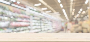 Boş ahşap masa üstü, soyut bulanık taze organik meyve ve sebzelerle marketin arka planında çözünmüş.