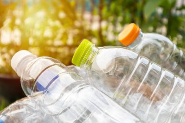 Kahverengi çöp kutusundaki plastik şişeler