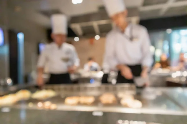 Chef cooking in restaurant kitchen blurred defocused background