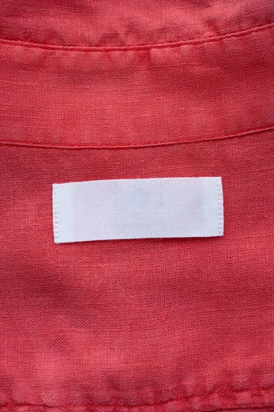 Label Tag Pakaian Kosong Putih Pada Latar Belakang Tekstur Kemeja — Stok Foto