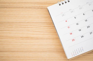 Tahta masa arkaplanındaki takvim sayfası