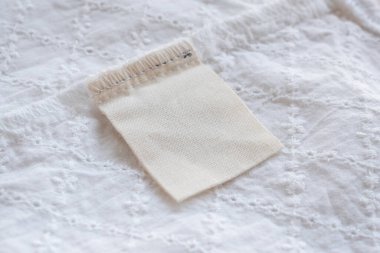 Kumaş dokusu arka planında boş çamaşırhane kıyafetleri etiketi