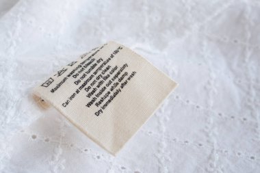 Çamaşır yıkama talimatları kumaş dokusu arka planında etiket