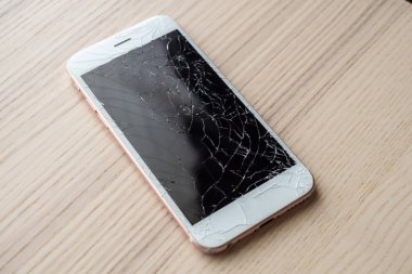 Ahşap arka planda kırılmış cep telefonu ekranı