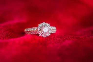 Kırmızı kumaş arka planda lüks mücevher yüzüğü