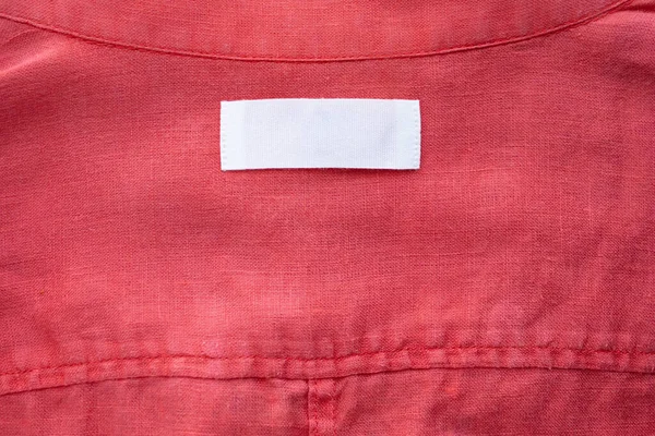 Etiqueta Blanca Etiqueta Ropa Blanco Sobre Tela Camisa Lino Rojo — Foto de Stock