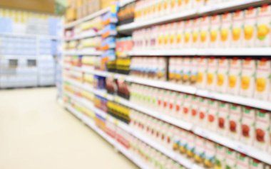 Raflarda meyve suyu içeceği bulunan süpermarket soyut bulanık arka planda