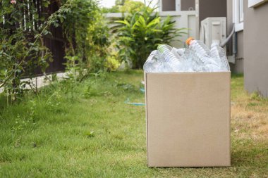 Kahverengi çöp kutusundaki plastik şişeler
