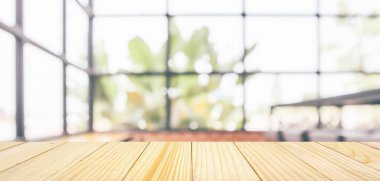 Boş ahşap masa üstü, kafeterya kafesi penceresi, soyut bulanıklık, montaj ürünü gösterimi için bokeh ışığı arkaplanı.