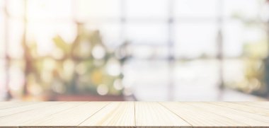 Boş ahşap masa üstü, kafeterya kafesi penceresi, soyut bulanıklık, montaj ürünü gösterimi için bokeh ışığı arkaplanı.