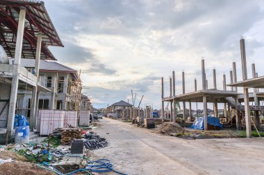 Bulutları ve mavi gökyüzü olan inşaat sahasında inşaat devam ediyor.