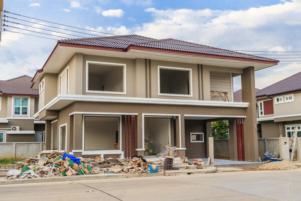 строится новый жилой дом на стройплощадке с облаками и голубым небом