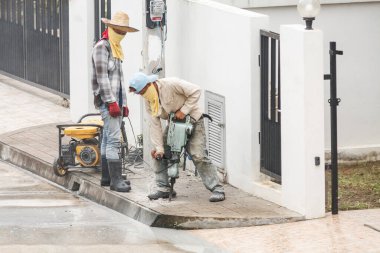 İnşaat işçisi beton sondaj yüzeyi kullanıyor.
