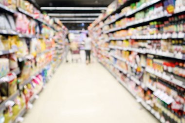 Müşteri alışverişiyle süpermarket koridoru ve raflardan seçilen ürün odaklı bulanık arkaplan