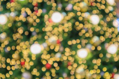 Soyut noel tatili. Ağaçtaki altın renkli ışık bulanık arka planda.