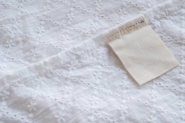 Kumaş dokusu arka planında boş çamaşırhane kıyafetleri etiketi