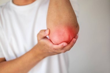 Genç adam dirsek sağlığı konseptinde acı hissediyor.