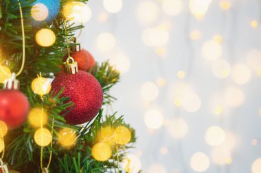 Arka plandaki çam dallarında kırmızı top ile süslenmiş Noel ağacı