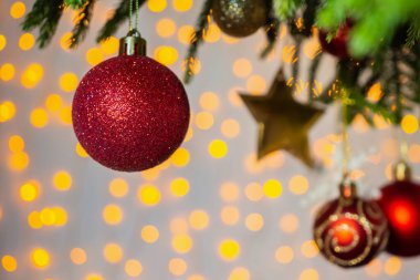 Arka plandaki çam dallarında kırmızı top ile süslenmiş Noel ağacı