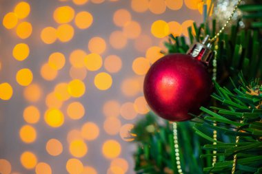 Arka plandaki çam dallarında kırmızı top ile süslenmiş Noel ağacı