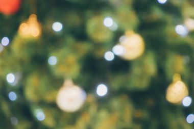 Soyut noel tatili. Ağaçtaki altın renkli ışık bulanık arka planda.