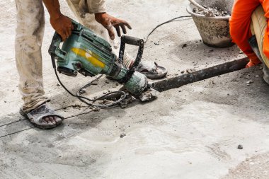 İnşaat işçisi beton sondaj yüzeyi kullanıyor.