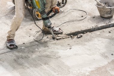 İnşaat işçisi beton sondaj yüzeyi kullanıyor.