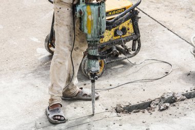 İnşaat işçisi beton sondaj yüzeyi kullanıyor.