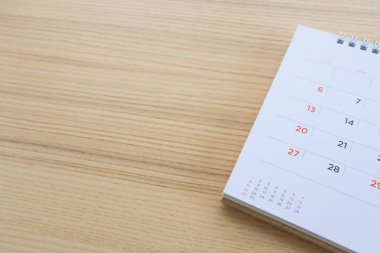 Tahta masa arkaplanındaki takvim sayfası