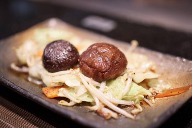 Teppanyaki restoranında kızarmış Shiitake mantarını sebze yemeğiyle karıştır.