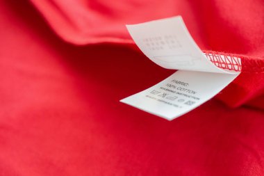 Beyaz çamaşır yıkama talimatları kırmızı pamuklu gömlekte etiket